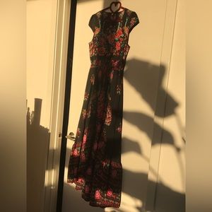 Black printed dress. With buttons and tie. Opens in the front.